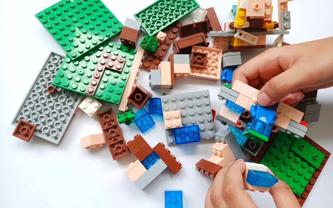 A child's hand is holding a Lego toy