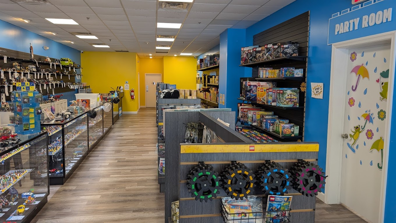2026-05-04 Interior of a toy store featuring a variety of LEGO sets displayed on shelves and tables, with colorful decor and organized product displays