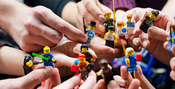 several hands holding minifigs