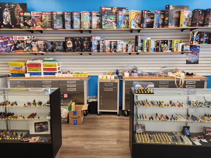 interior of toy store showing LEGO® minifigures in display case and LEGO® sets on shelves