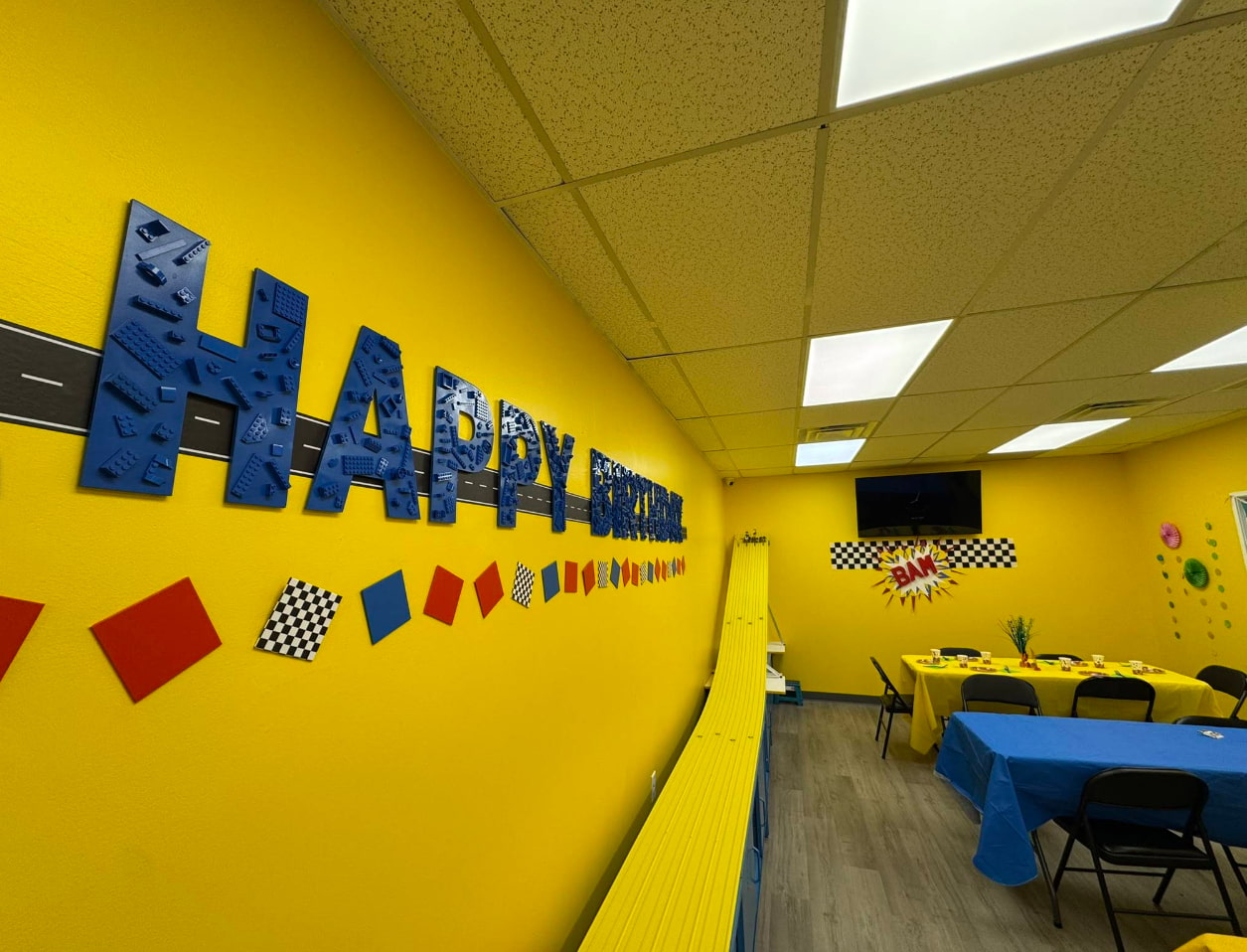 interior of birthday party room at toy store showing decor and tablesqq