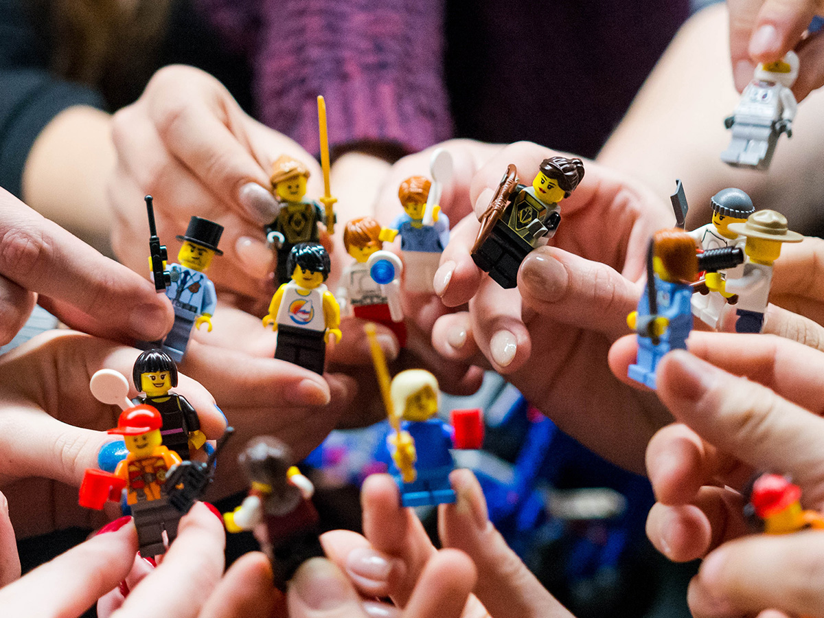 Different people holding all sorts of LEGO® minifigs.
