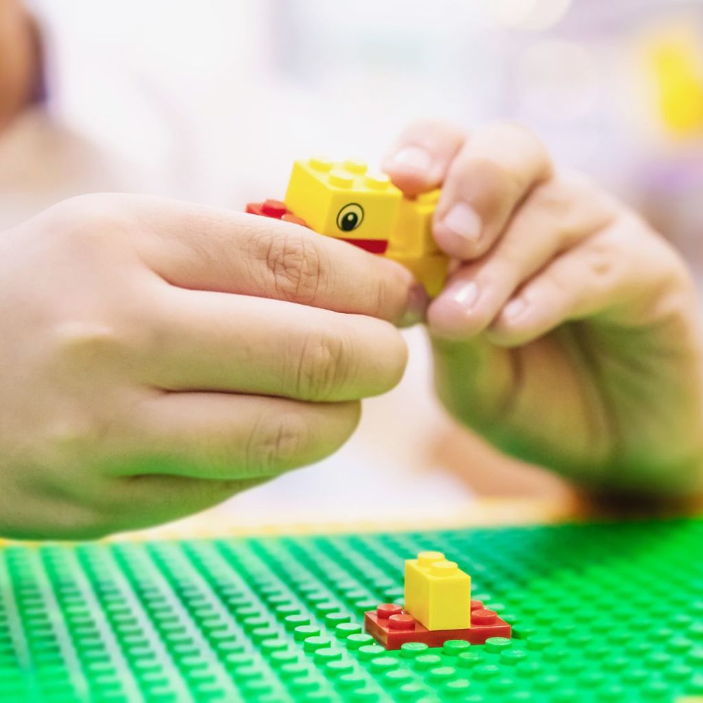 a kid playing with LEGOs