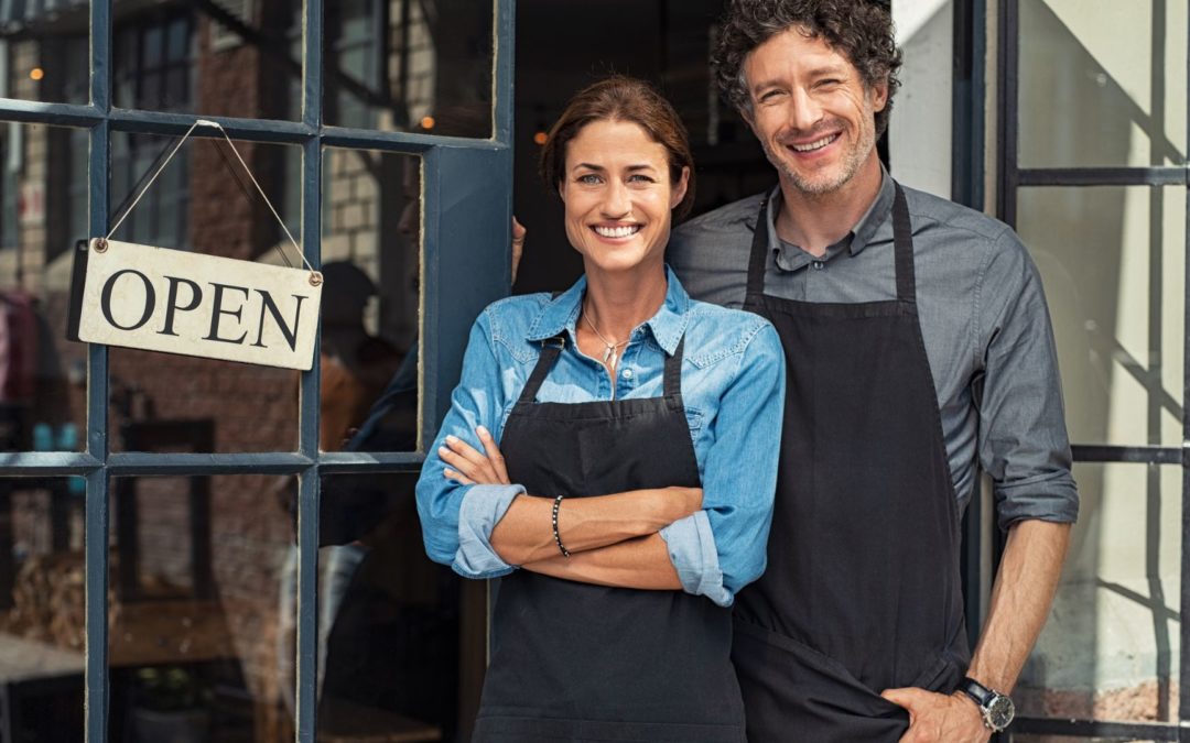 Couple in front of business with open sign