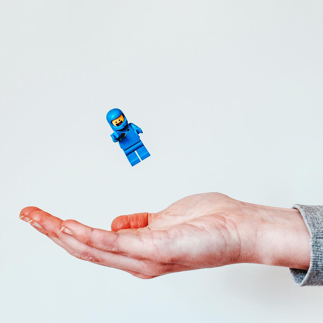 Hand held out ready to catch a blue Lego figurine