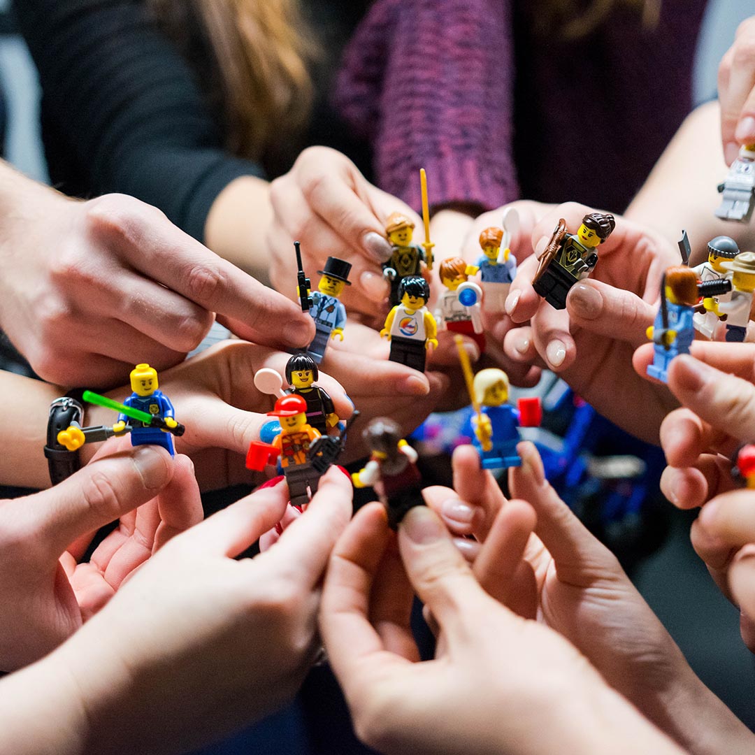 Hands holding Lego figurines