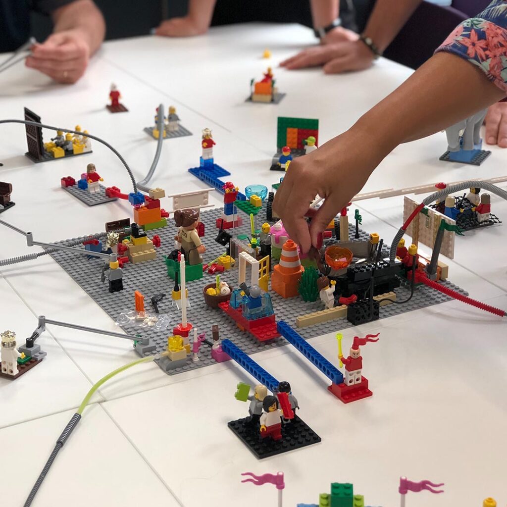 group of people building a lego scene