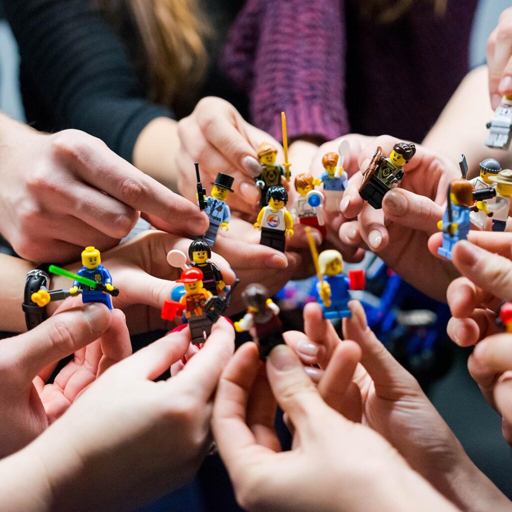 people holding lego figurines