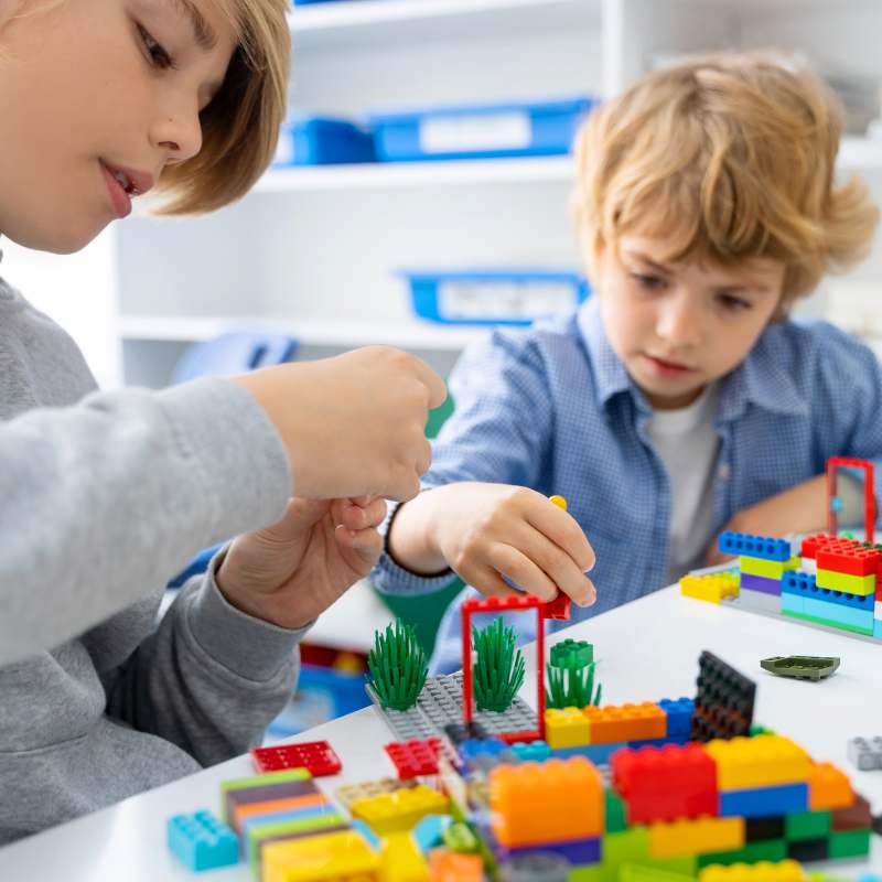 Two children creating a building with LEGO® bricks.