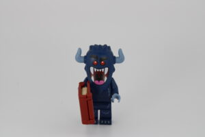 A purple monster minifig with horns, red eyes, holding a LEGO® book