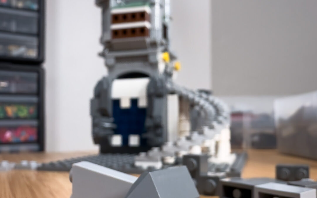 A close up shot of LEGO® pieces on a table with a half-built castle in the background.