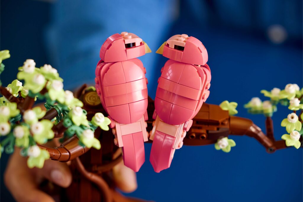 A closeup of the Love Birds LEGO® set featuring the two pink birds sitting on brick-built branch.